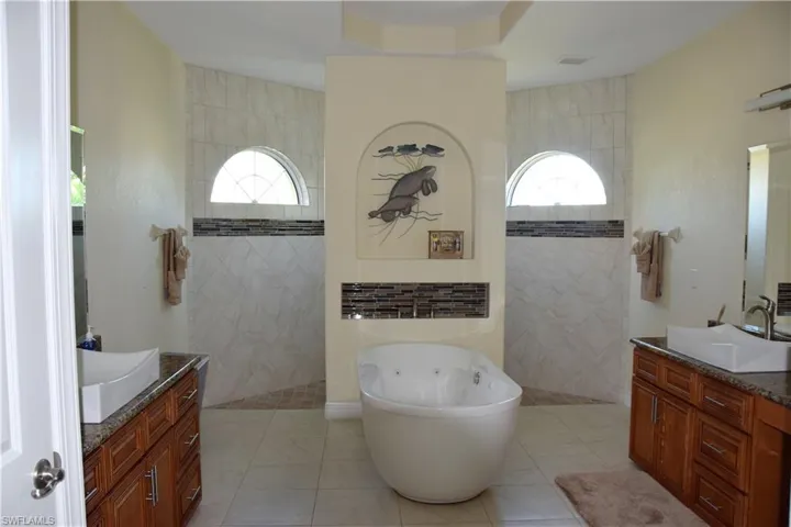 Bathroom with tile patterned floors, plenty of natural light, and tile walls