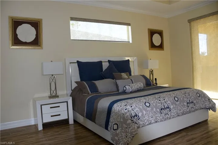 Bedroom featuring dark hardwood / wood-style floors and ornamental molding