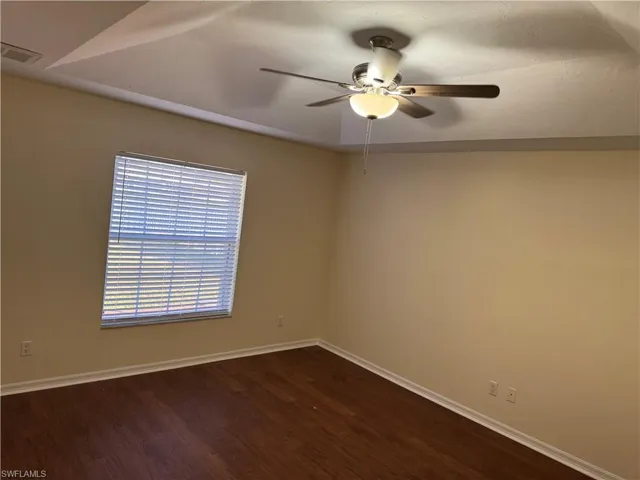 Spare room with dark wood-style floors and ceiling fan