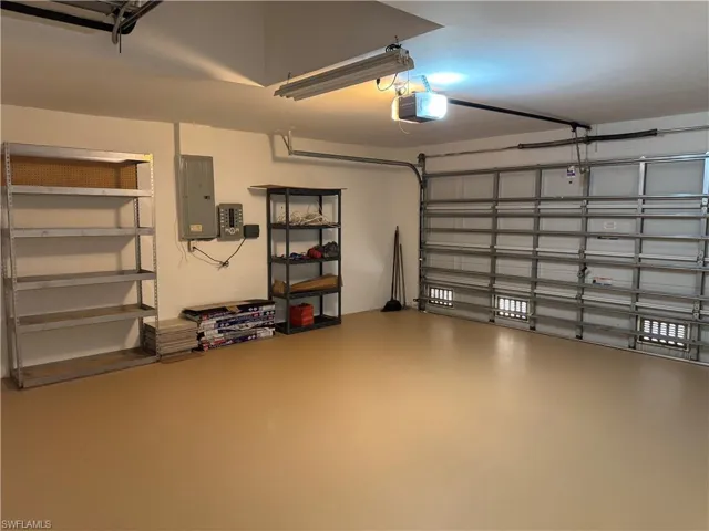 Garage featuring electric panel and a garage door opener