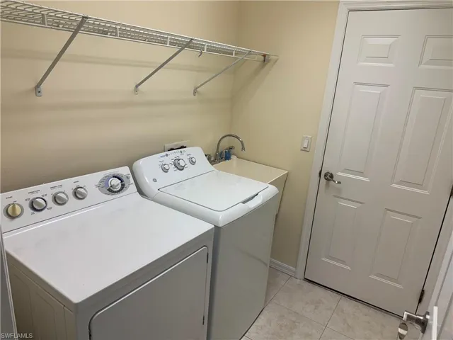Laundry room featuring washer and dryer and light tile patterned floors