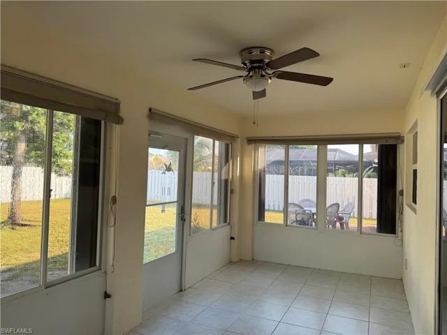Unfurnished sunroom with tile patterned flooring and ceiling fan