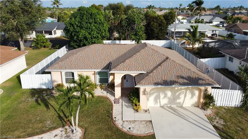 View of front of home with stucco siding, concrete driveway, a garage, and a residential view