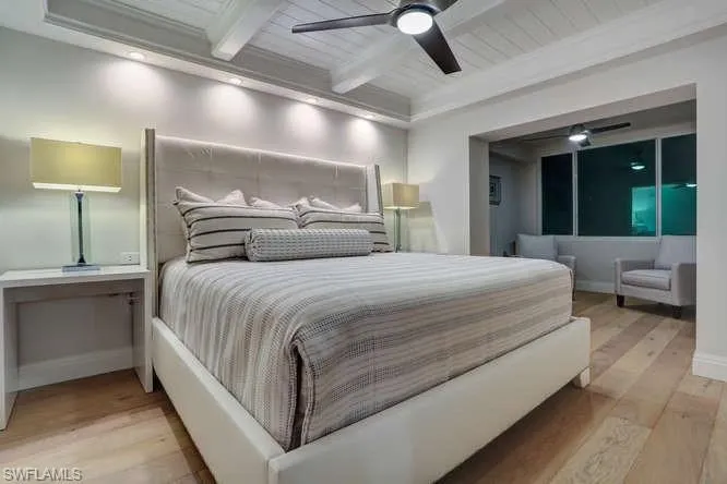 Bedroom featuring ceiling fan, beamed ceiling, crown molding, wood ceiling,  wood flooring with sitting room/den