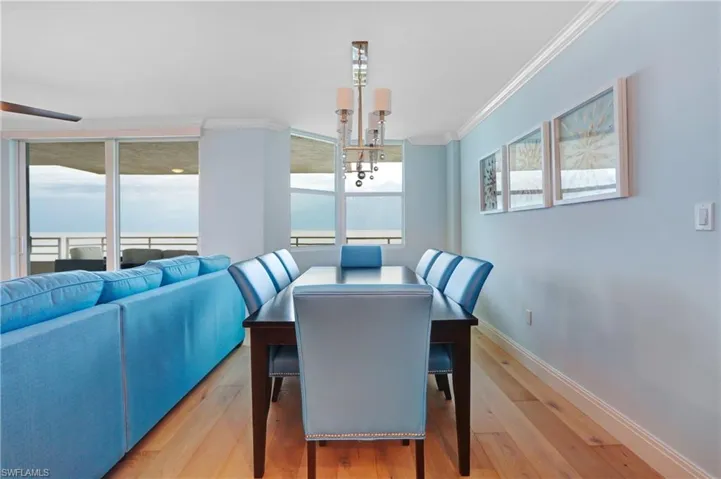 Dining room featuring a healthy amount of sunlight, wood-type flooring, and crown molding