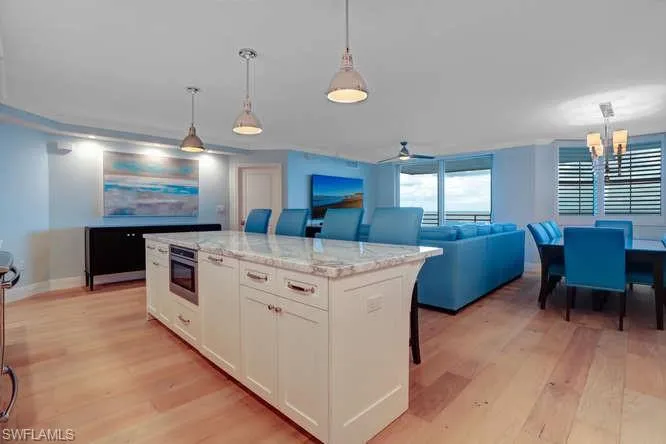 Kitchen featuring white cabinetry, a kitchen island, light hardwood / wood floors, and decorative light fixtures