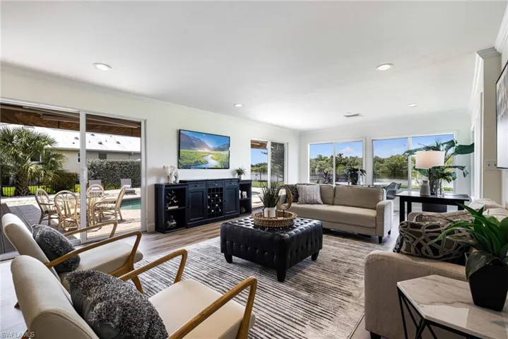 Living area featuring ornamental molding, wood finished floors, plenty of natural light, and recessed lighting