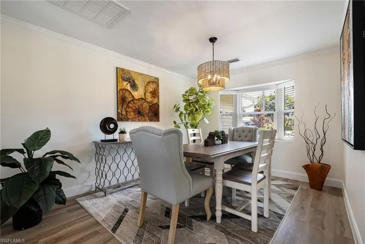 Dining room featuring ornamental molding and wood finished floors