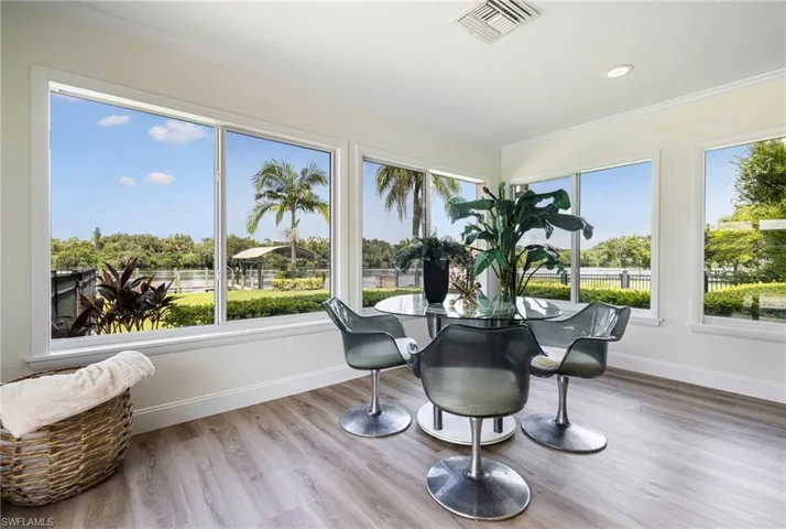 Sunroom featuring wood finished floors, crown molding, and recessed lighting