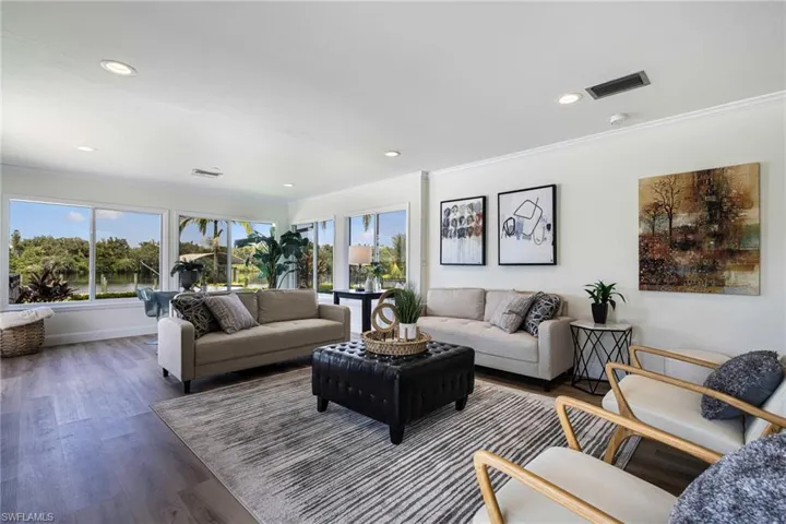 Living room featuring wood finished floors, ornamental molding, and recessed lighting
