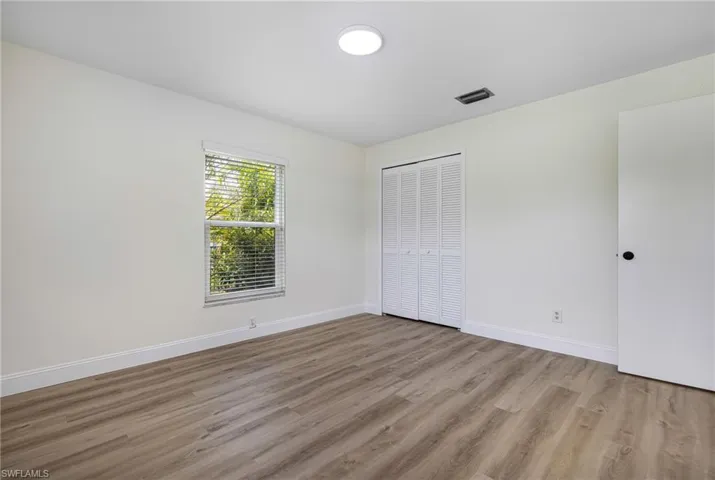 Unfurnished bedroom featuring light wood-style floors and a closet