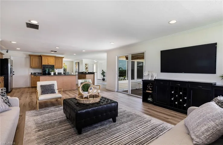 Living area featuring recessed lighting, light wood-type flooring, and ornamental molding