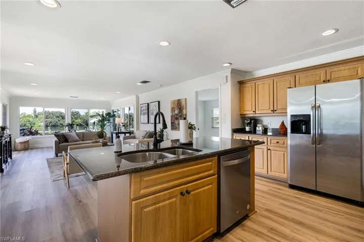 Kitchen with appliances with stainless steel finishes, brown cabinetry, recessed lighting, a kitchen island with sink, and plenty of natural light