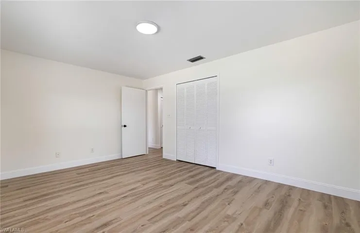 Unfurnished bedroom featuring light wood-type flooring and a closet