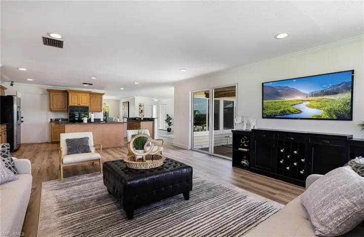 Living area with recessed lighting, light wood-style flooring, and crown molding
