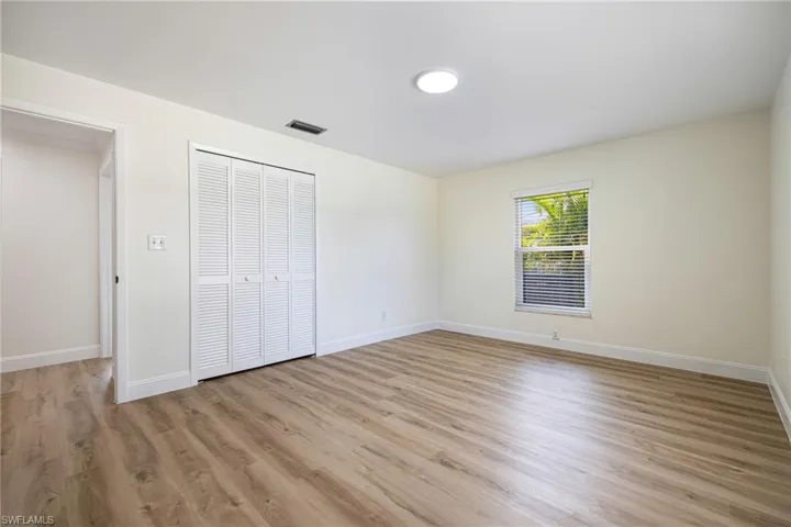 Unfurnished bedroom featuring light wood finished floors and a closet
