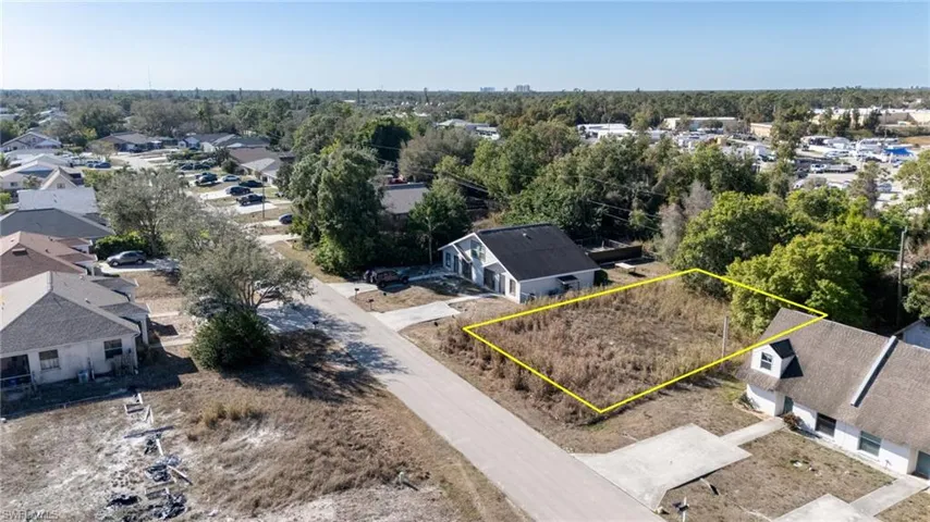 Aerial perspective of suburban area with property boundaries highlighted and a tree filled landscape