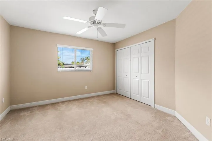 Unfurnished bedroom featuring baseboards, a closet, carpet, and a ceiling fan