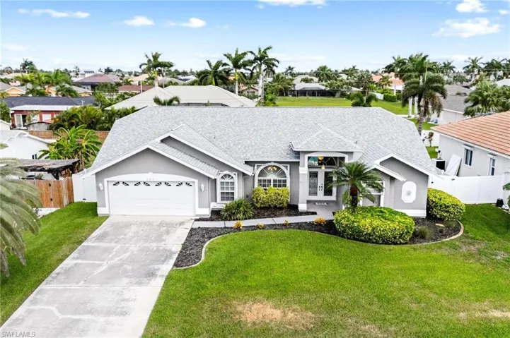 Ranch-style home with stucco siding, a garage, concrete driveway, and a front yard