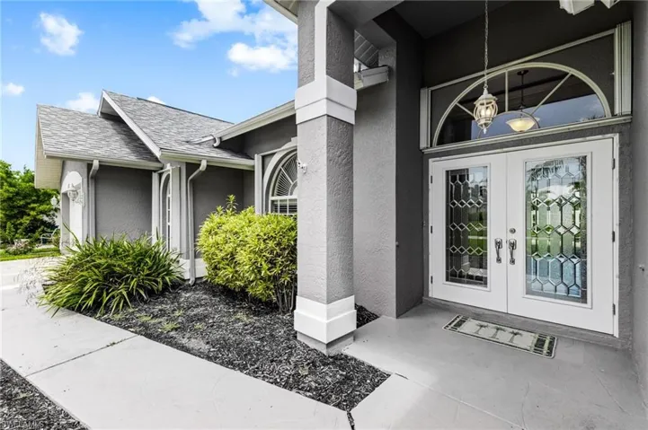 Doorway to property featuring stucco siding and french doors