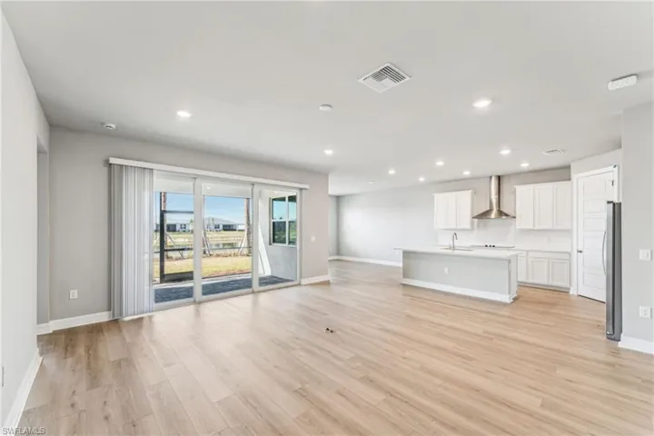 Unfurnished living room with sink and light wood-type flooring