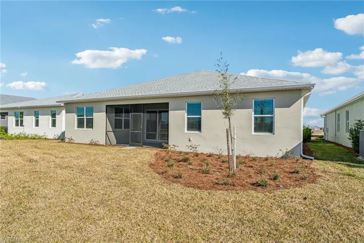 Back of property featuring a yard and a sunroom