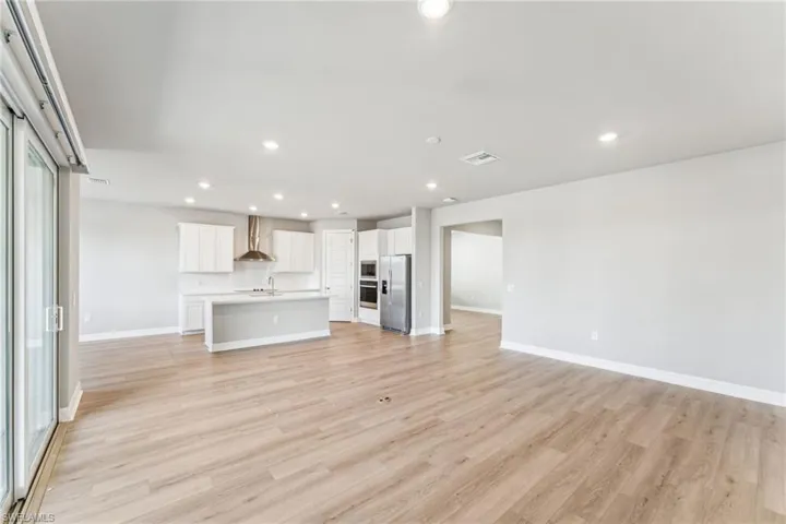 Unfurnished living room with sink and light wood-type flooring