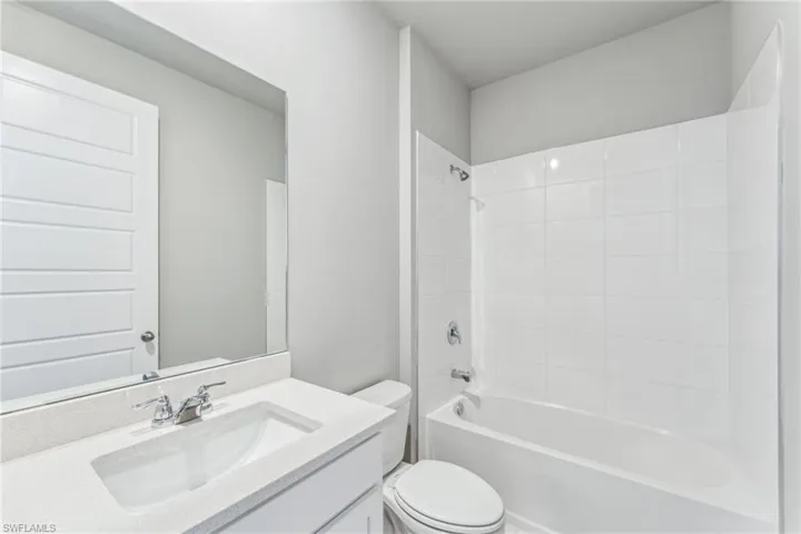 Full bathroom with bathing tub / shower combination, vanity, and toilet