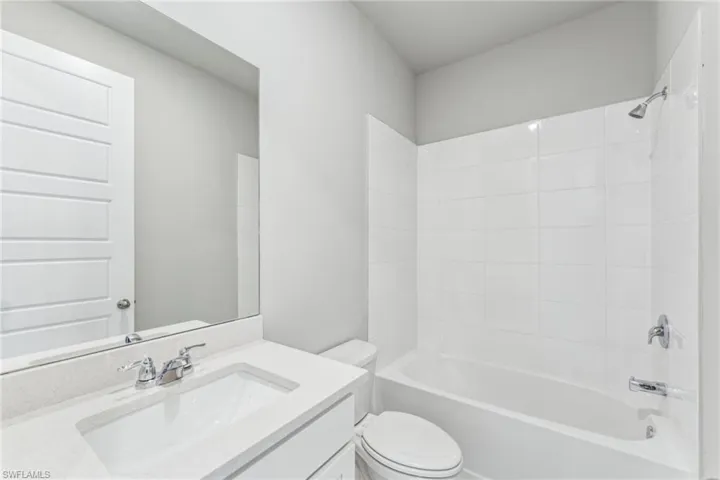 Full bathroom featuring vanity, bathtub / shower combination, and toilet