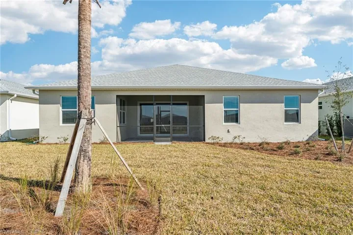 Back of property featuring a yard and a sunroom