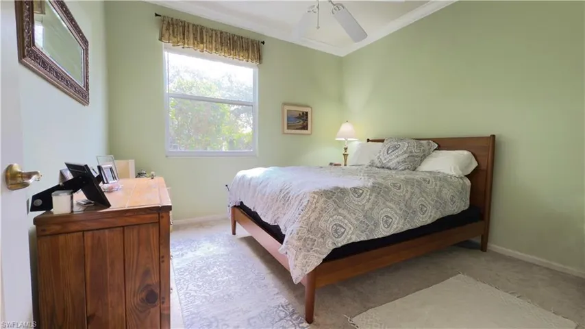 Carpeted bedroom with crown molding and ceiling fan
