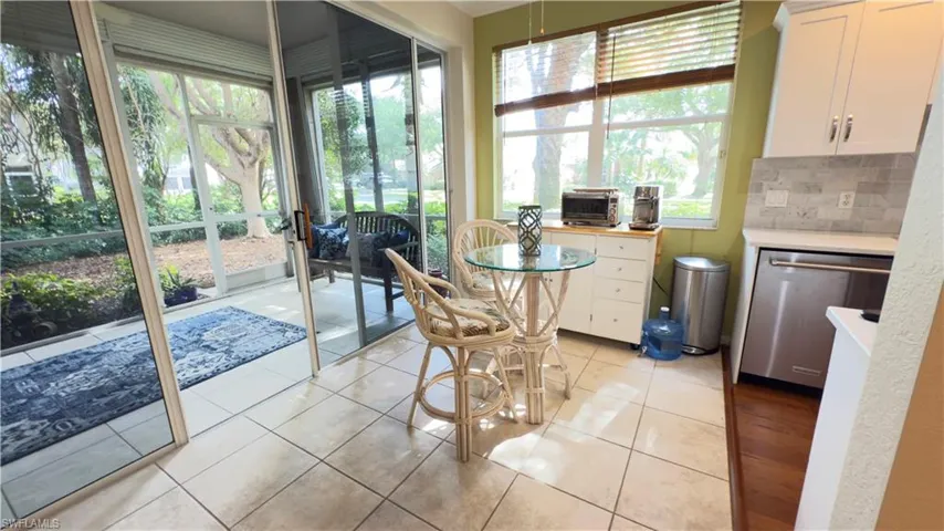 Eat in area off kitchen with newer fan/light fixture next to Lanai/ solarium with tile patterned flooring