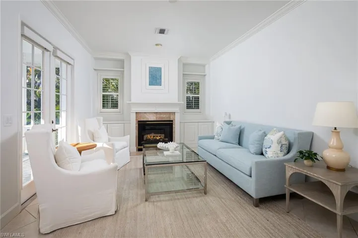 Living room featuring a premium fireplace and crown molding