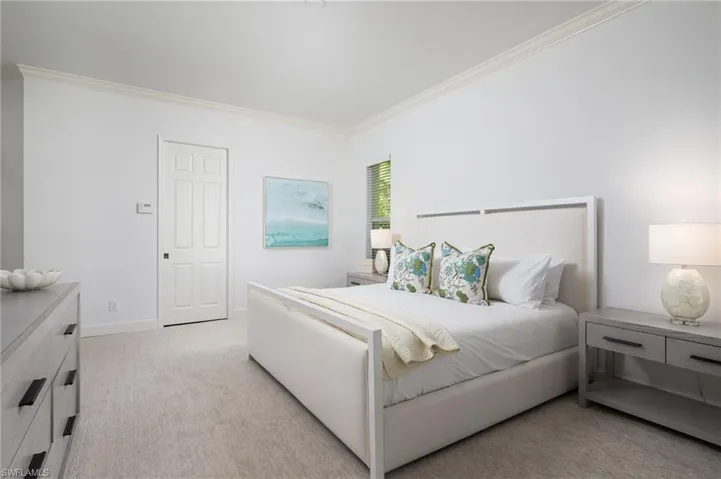 Bedroom featuring light colored carpet and crown molding