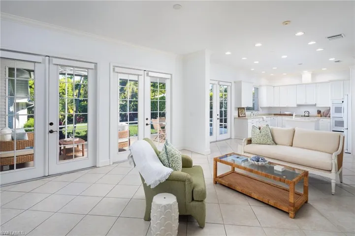 Living room with french doors, crown molding, light tile patterned floors, and recessed lighting