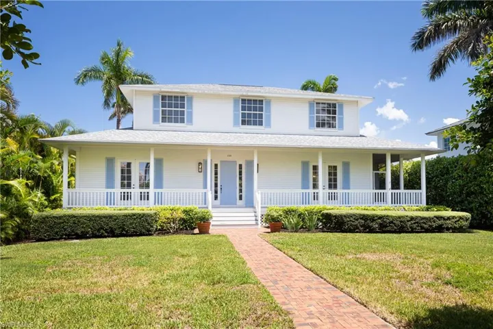 Farmhouse inspired home with a large porch and a front yard