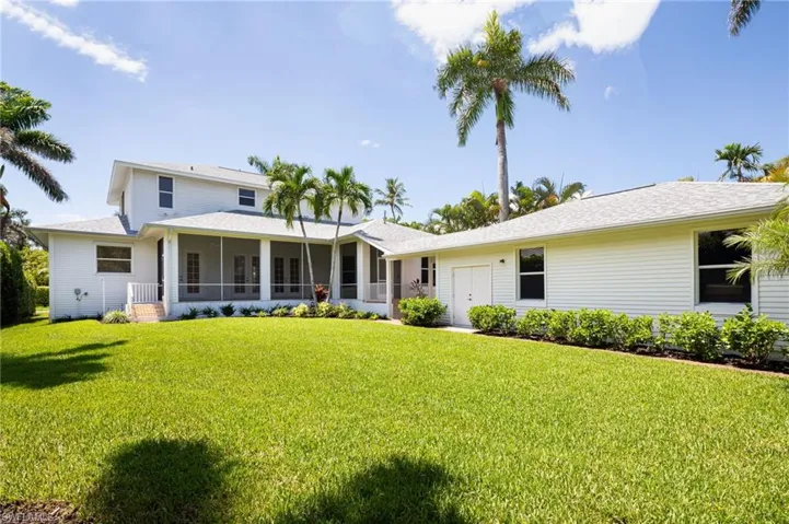 Back of property with a sunroom and a yard