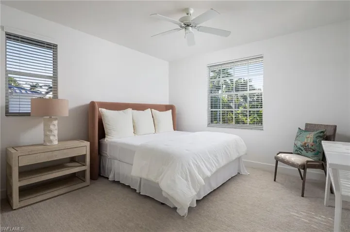 Bedroom with light colored carpet and a ceiling fan