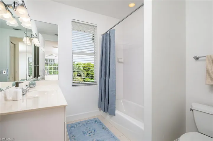 Full bath featuring vanity, light tile patterned floors, and shower / bath combination with curtain