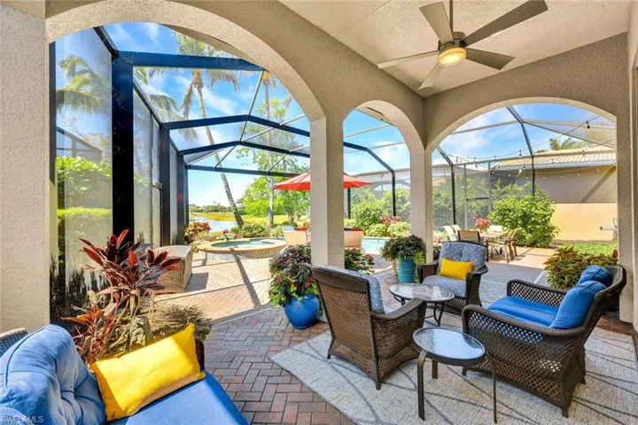 View of patio with an in-ground spa (2018), a sunroom, glass enclosure, and a ceiling fan