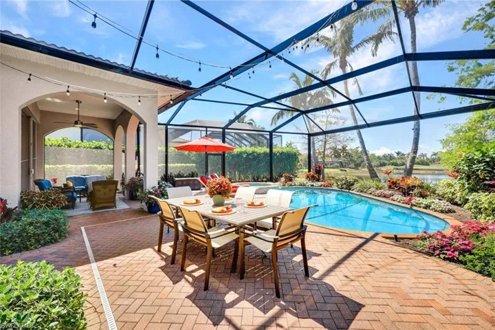 Outdoor pool with a ceiling fan, a sunroom, glass enclosure, outdoor dining space, and a patio