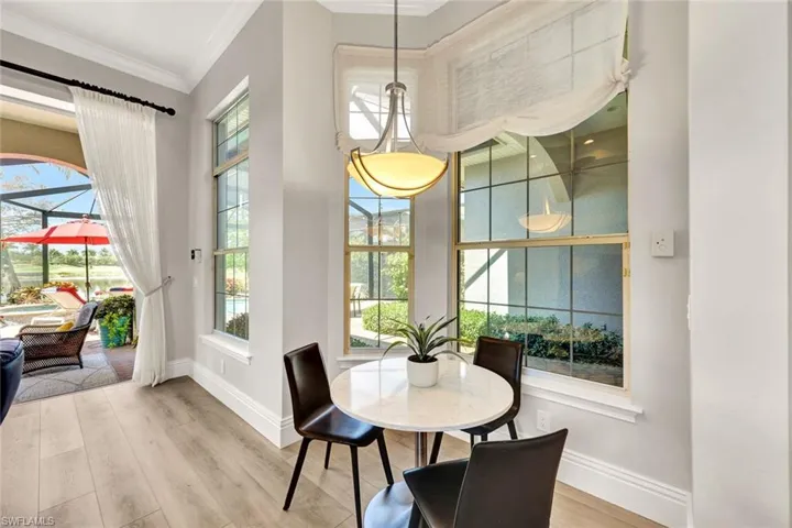 Dining room with light wood finished floors and crown molding