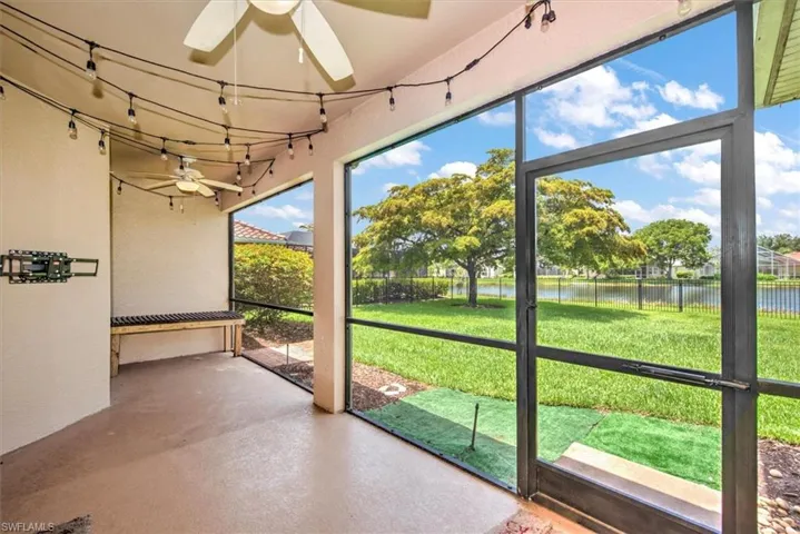 Unfurnished sunroom with ceiling fan and a water view