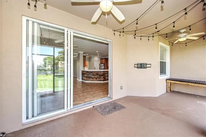 View of exterior entry with a patio and ceiling fan