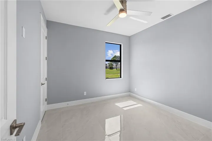Empty room featuring ceiling fan and light tile flooring