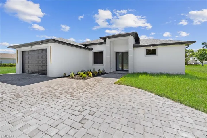 View of front of home featuring a front lawn and a garage