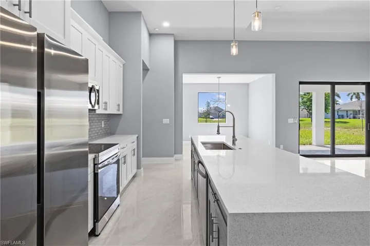 Kitchen featuring appliances with stainless steel finishes, sink, a wealth of natural light, and light tile floors