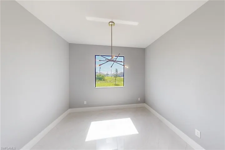 Empty room featuring tile floors and an inviting chandelier