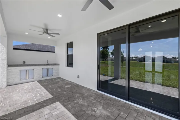 Unfurnished sunroom featuring ceiling fan