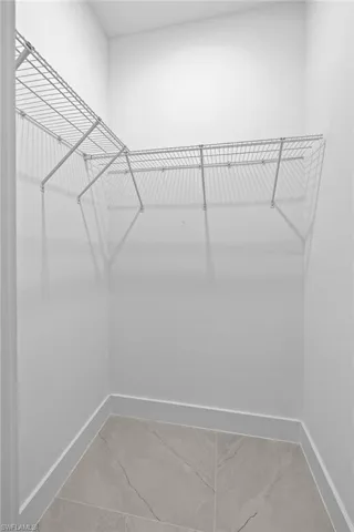 Walk in closet with tile flooring
